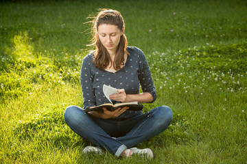 girl reading the Bible sitting outdoors