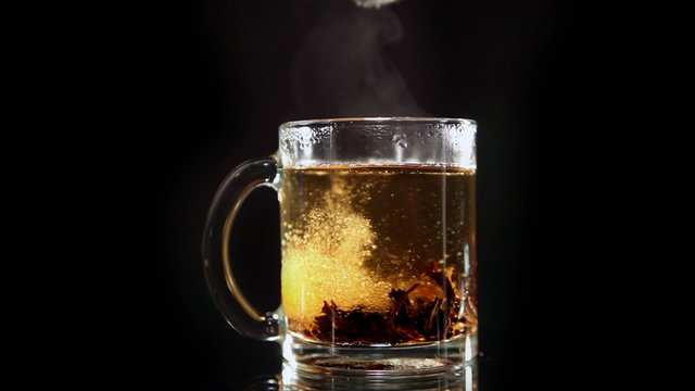 The Transparent Glass Cup of Tea is Poured White Granulated Sugar
