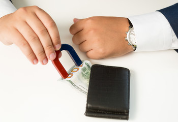 Closeup of man in suit pulling money out wallet with magnet