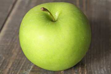 Green apple on wooden background
