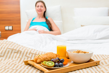 Fototapeta na wymiar breakfast in bed of a hotel room of a beautiful brunette