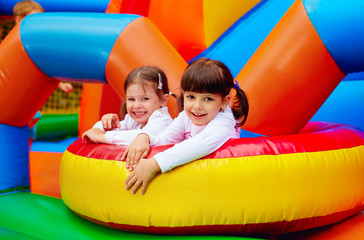 happy kids, girls having fun on inflatable attraction playground