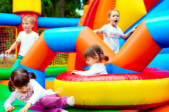 Happy Kids, Having Fun On Inflatable Attraction Playground