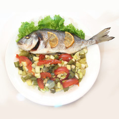 Sea Bream fish with vegetables on white plate