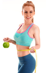 Young woman holding measure tape and apple. Weight loss