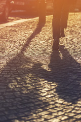 Running Boy Shadow on Cobblestone Pavement