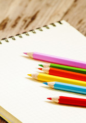 Pink school notebook in the box and colored pencils, selective f