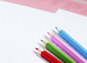 Pink school notebook in the box and colored pencils, selective f