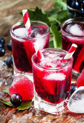 Fresh blackcurrant drink with berries and ice in a heart shape,