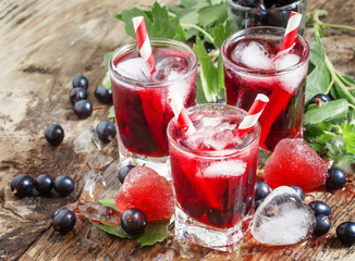 Fresh blackcurrant drink with berries and ice in a heart shape,