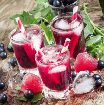 Fresh blackcurrant drink with berries and ice in a heart shape,