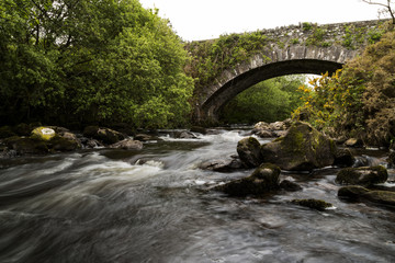 Fototapeta na wymiar alte Steinbrücke über fließendem Wasser