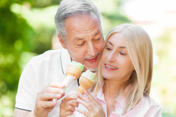 Happy mature couple eating an ice-cream