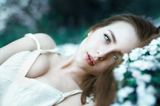 Beautiful sensual girl lying on flower meadow