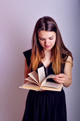 young caucasian female with books on grey background, education concept