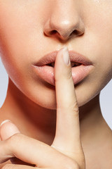 close-up of a woman with a finger to his lips