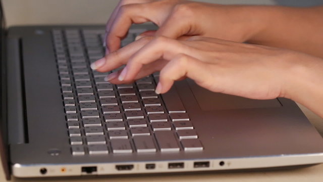 hands typing on a laptop keyboard