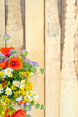 Fototapeta na wymiar bright multicolored bouquet of wildflowers daisies, poppies, clo