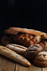 Assortment of fresh bread on a wooden background