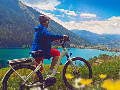 woman with bike enjoying view on a lake/e-bike power 04