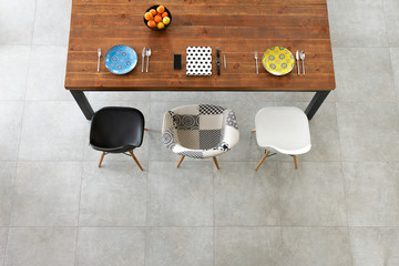 Dining wooden table, color porcelain plates, phone, watch and notebook