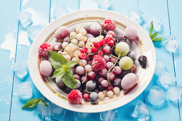 Frozen berries in the plate on wooden table
