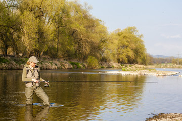 Fototapeta premium woman fishing in the river in spring