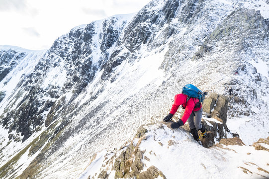 A climber ascending a snow covered ridge