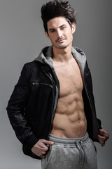 Athletic man wearing hoodie jacket. Studio shot