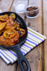 Delicious baked chicken thighs with lemon slices, onion and zucchini 