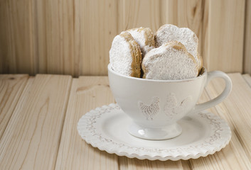 Spanish cookies for fat in a cup with a bouquet of roses 