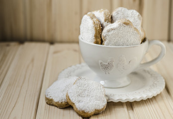 Fototapeta na wymiar Spanish cookies for fat in a cup with a bouquet of roses 