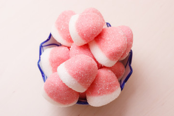 Pink jellies or marshmallows with sugar in bowl