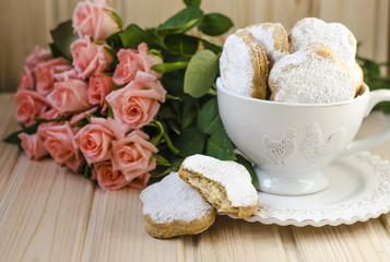 Spanish cookies for fat in a cup with a bouquet of roses 