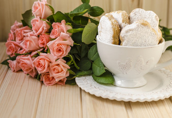 Obraz na płótnie Canvas Spanish cookies for fat in a cup with a bouquet of roses 