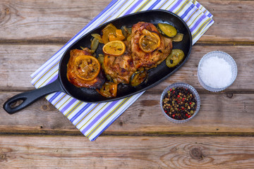 Delicious baked chicken thighs with lemon slices, onion and zucc