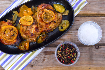 Delicious baked chicken thighs with lemon slices, onion and zucc