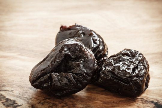 dried plums prunes on wooden table