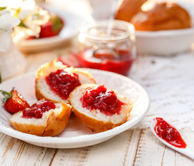 Homemade strawberry jam on a buttery scones