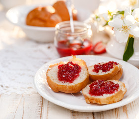 Homemade strawberry jam on a buttery scones