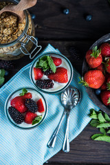 Homemade parfait with fresh fruit and cream on wooden background