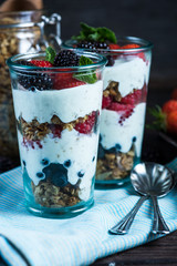 Homemade parfait with fresh fruit and cream on wooden background