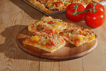 Pizza mit Paprika, Tomaten, Schinken, Zwiebeln, Käse