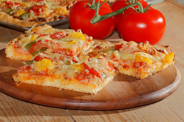 Pizza mit Paprika, Tomaten, Schinken, Zwiebeln, Käse