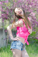 Beautiful fit lady between blossom tree in purple color