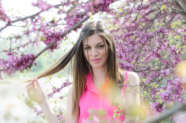 Fototapeta premium Beautiful fit lady between blossom tree in purple color
