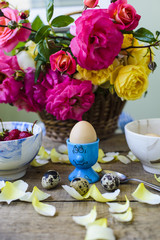 fresh breakfast, eggs, strawberry and roses on wooden table