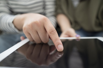 Women who are looking at the tablet together