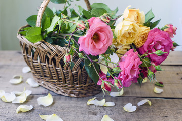 Obraz premium bouquet of pink and yellow roses in a wicker basket