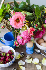 fresh breakfast, eggs, strawberry and roses on wooden table